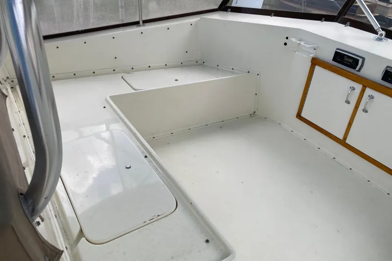 Slide: The Image of 1985 Hatteras Sportfish boat interior with white seating and storage compartments. - 13