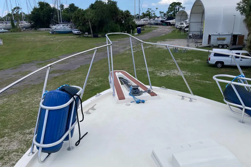 Slide: The Image of 1985 Hatteras Sportfish boat deck with railing and blue fenders in a marina setting. - 17