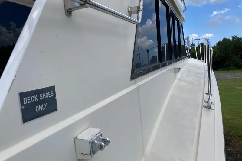 Slide: The Image of 1985 Hatteras Sportfish yacht with "Deck Shoes Only" sign, side view. - 20