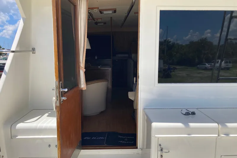 Slide: The Image of 1985 Hatteras Sportfish yacht interior view with open door and outdoor seating. - 21