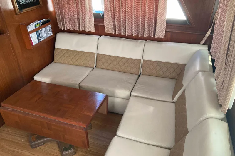 Slide: The Image of Interior of 1985 Hatteras Sportfish with beige seating and wooden table. - 22
