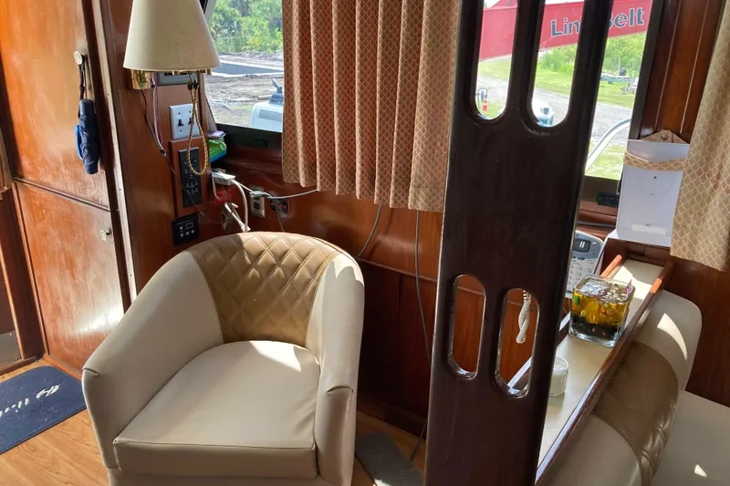 Slide: The Image of Interior of a 1985 Hatteras Sportfish boat with a beige chair and wooden accents. - 23