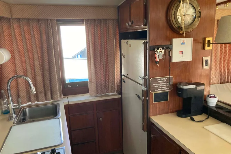 Slide: The Image of 1985 Hatteras Sportfish kitchen interior with sink, fridge, and coffee maker. - 28