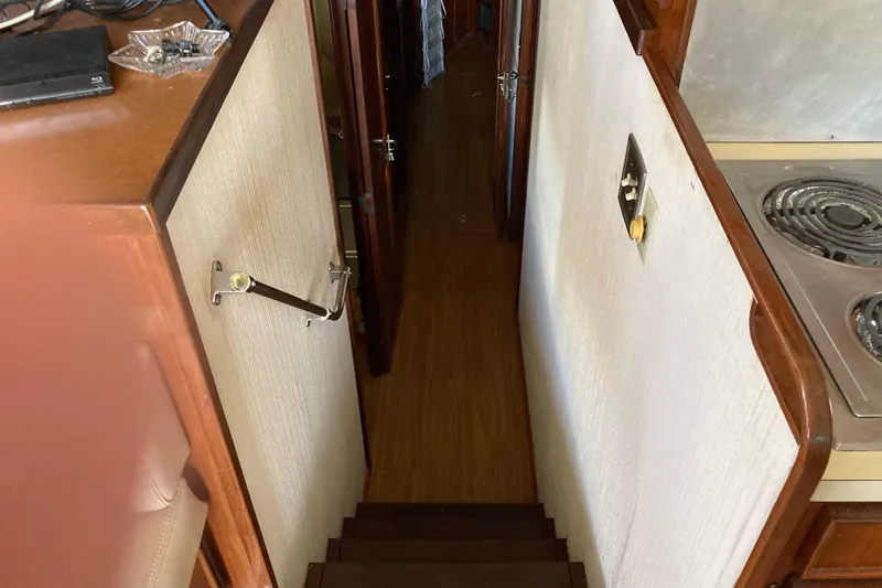 Slide: The Image of Interior view of 1985 Hatteras Sportfish yacht, featuring stairs and kitchen area. - 30