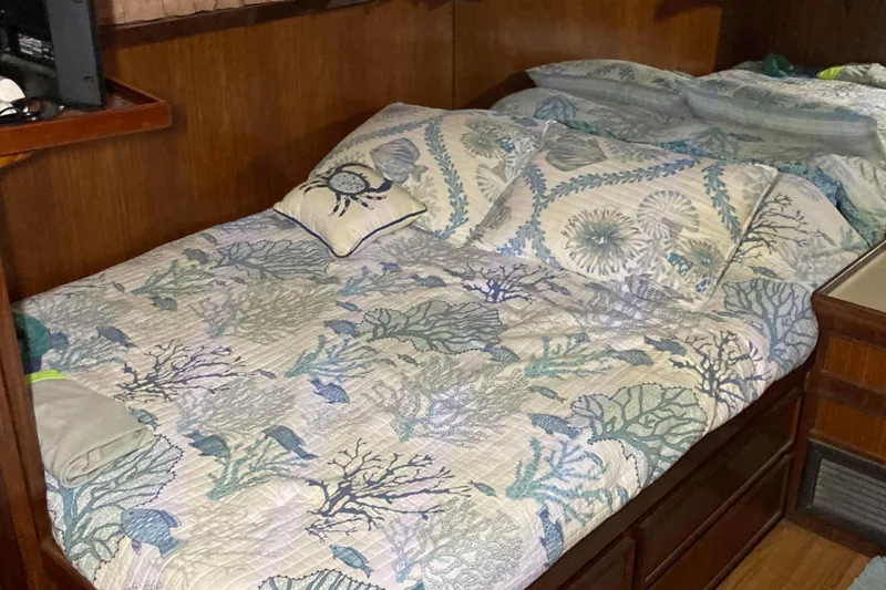 Slide: The Image of Cozy cabin bed with nautical-themed bedding on 1985 Hatteras Sportfish yacht. - 31