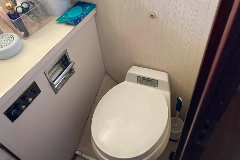 Slide: The Image of 1985 Hatteras Sportfish bathroom with toilet and countertop essentials. - 40