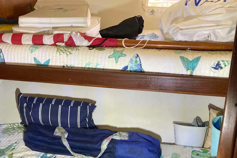 Slide: The Image of Interior of 1985 Hatteras Sportfish boat with nautical-themed bedding and storage. - 41