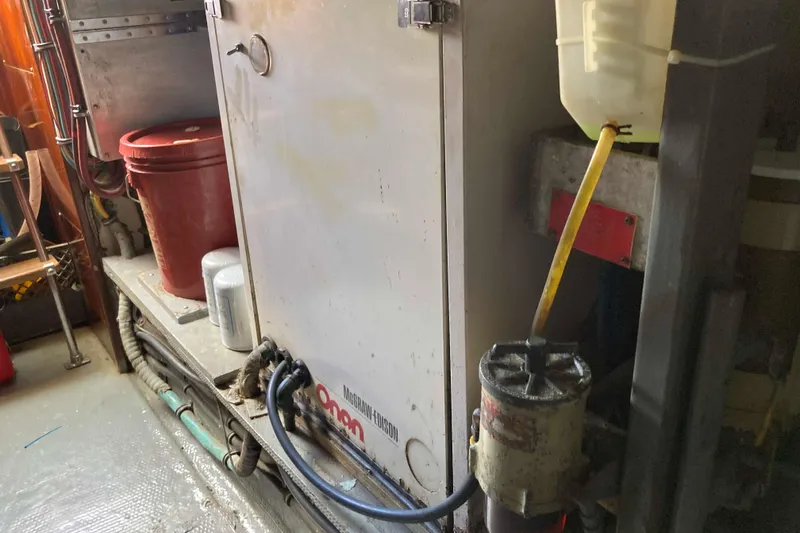 Slide: The Image of Engine room of 1985 Hatteras Sportfish with generator and maintenance equipment. - 49