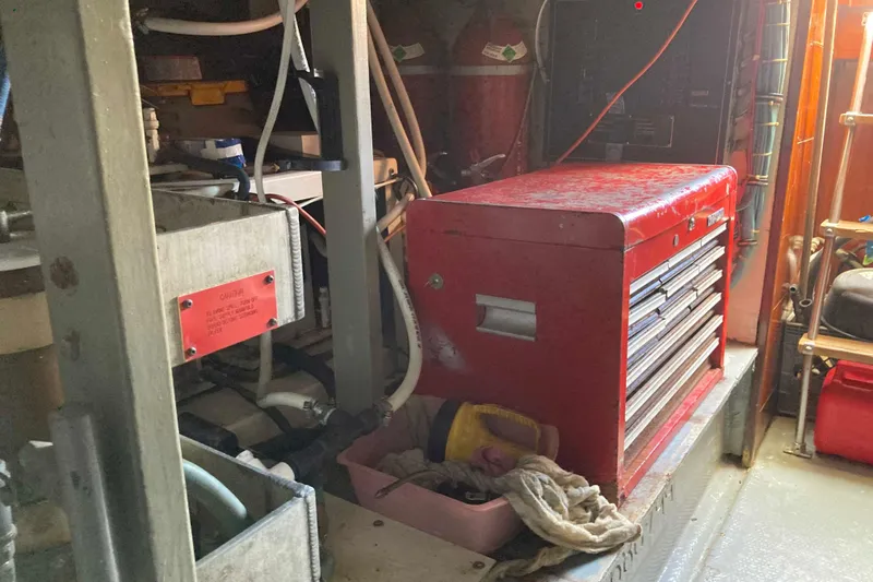 Slide: The Image of Engine room of 1985 Hatteras Sportfish with red tool chest and equipment. - 50