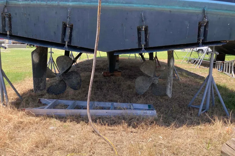 Slide: The Image of 1985 Hatteras Sportfish boat on stands, showing propellers and rudders. - 51