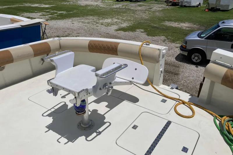 Slide: The Image of 1985 Hatteras Sportfish boat deck with fishing chair and coiled hose. - 7