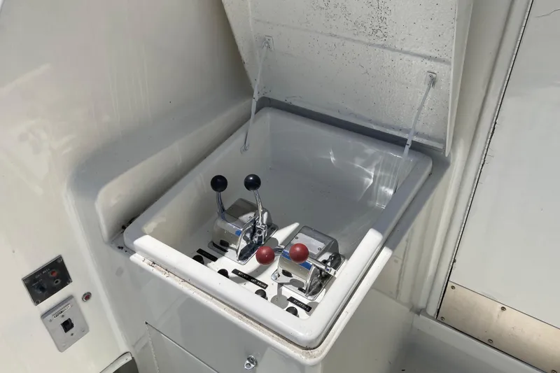 Slide: The Image of 1985 Hatteras Sportfish boat controls with dual levers in a white compartment. - 8