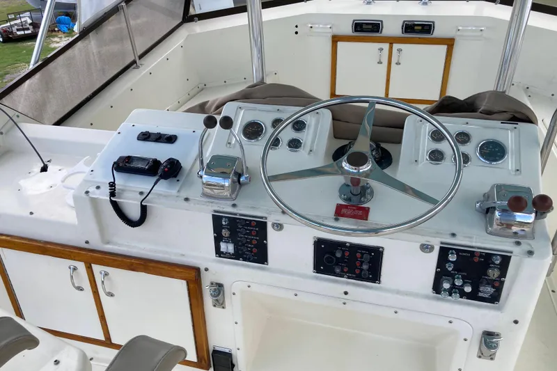 Slide: The Image of 1985 Hatteras Sportfish helm with steering wheel, controls, and navigation instruments. - 9