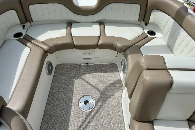 Slide: The Image of 2008 Searay SX 232 boat interior with beige and white seating, carpeted floor, and cup holders. - 14