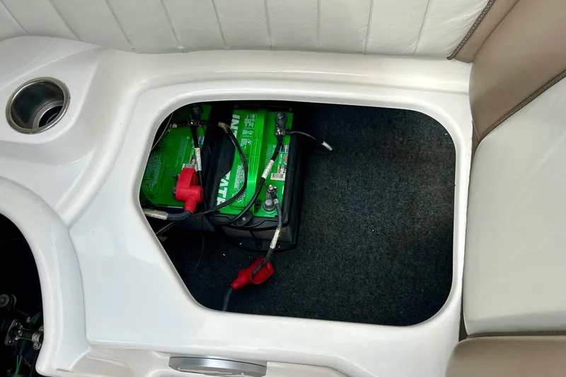 Slide: The Image of Battery compartment of a 2008 Searay SX 232 boat, featuring a green battery. - 32