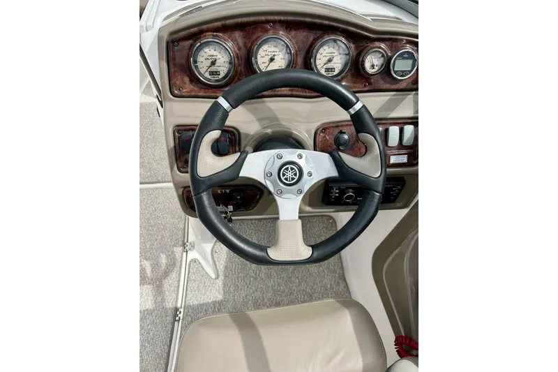 Slide: The Image of Steering wheel and dashboard of 2008 Searay SX 232 boat, featuring gauges and controls. - 33