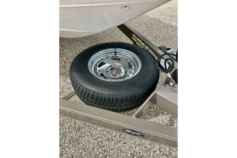 Slide: The Image of 2008 Searay SX 232 boat trailer with spare tire on gravel surface. - 37
