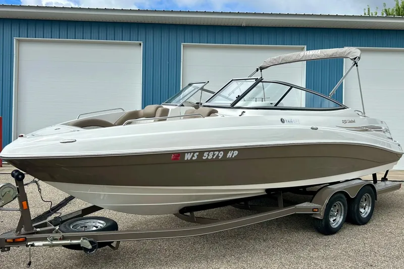 Slide: The Image of 2008 Searay SX 232 boat on trailer, parked near blue building. - 39