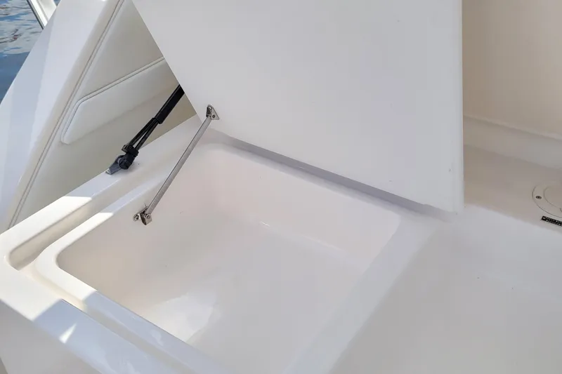 Slide: The Image of 1997 Wellcraft 330 Coastal boat storage compartment with open lid, showcasing interior space. - 17