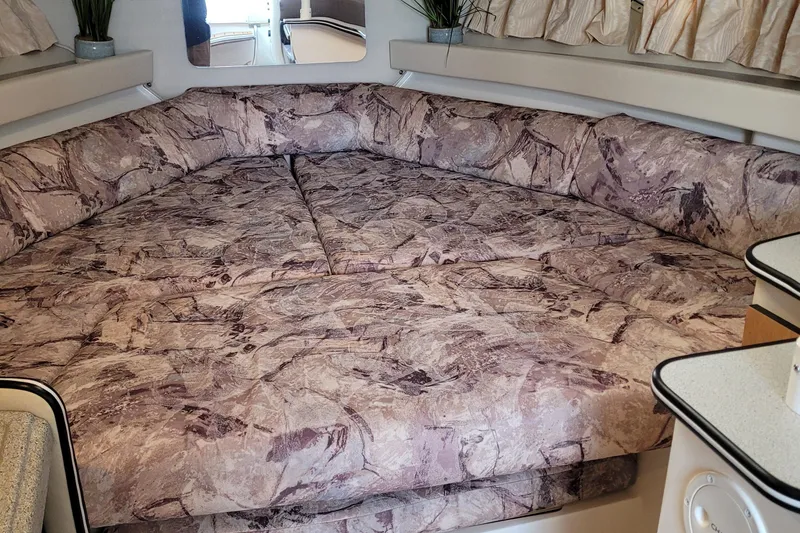 Slide: The Image of 1997 Wellcraft 330 Coastal cabin interior with patterned bedding and cozy seating area. - 19