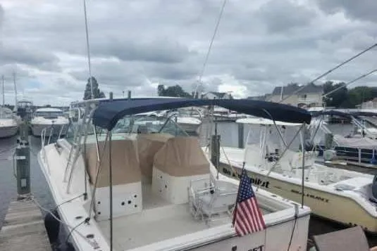 Slide: The Image of 1997 Wellcraft 330 Coastal boat docked at marina under cloudy skies. - 2