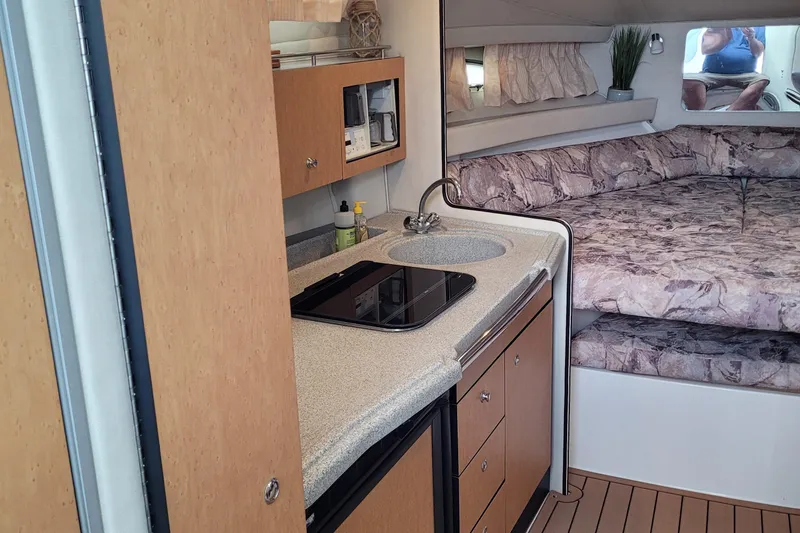 Slide: The Image of 1997 Wellcraft 330 Coastal interior with kitchenette and cozy sleeping area. - 21
