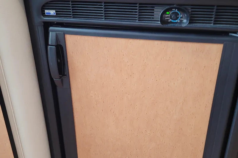 Slide: The Image of 1997 Wellcraft 330 Coastal interior fridge with wooden panel and black trim. - 22