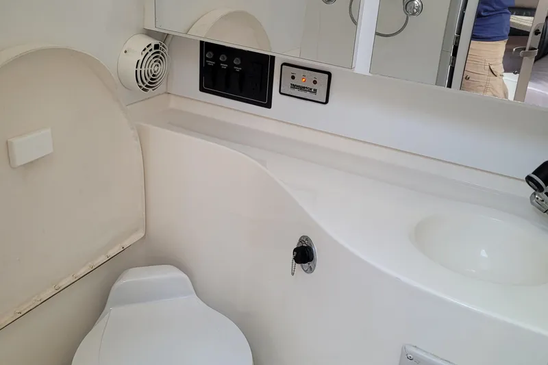 Slide: The Image of 1997 Wellcraft 330 Coastal boat bathroom with toilet, sink, and control panel. - 25