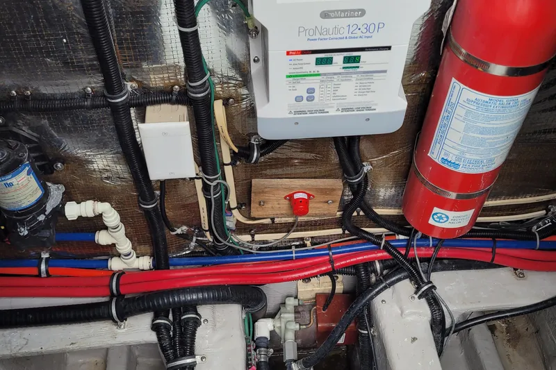 Slide: The Image of 1997 Wellcraft 330 Coastal engine room with wiring, ProNautic charger, and fire extinguisher. - 27