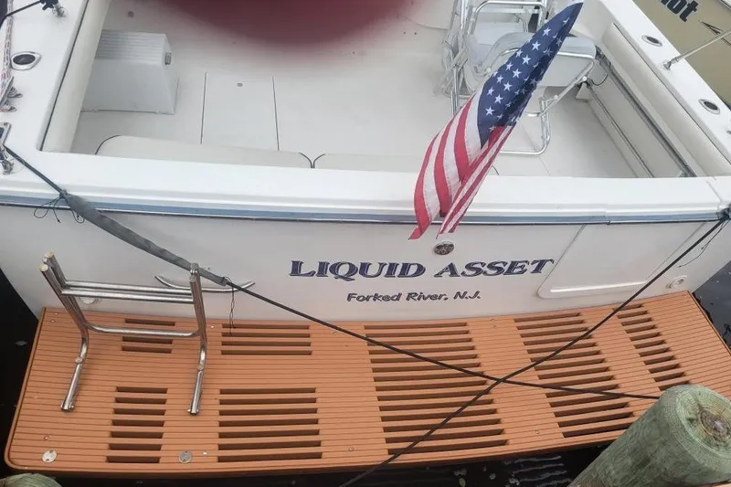 Slide: The Image of 1997 Wellcraft 330 Coastal boat with American flag, docked at Forked River, N.J. - 3