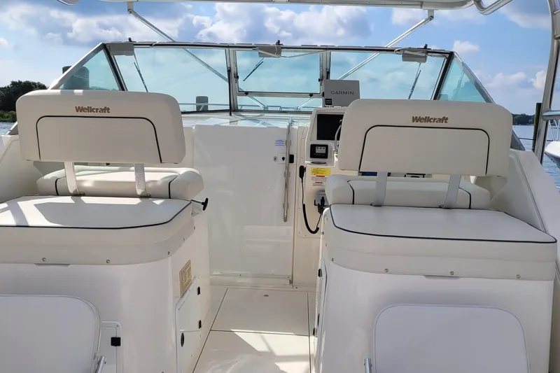 Slide: The Image of 1997 Wellcraft 330 Coastal boat cockpit with dual white seats and control panel. - 5