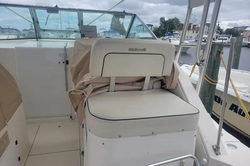 Slide: The Image of 1997 Wellcraft 330 Coastal boat interior with cushioned seating and marina view. - 6