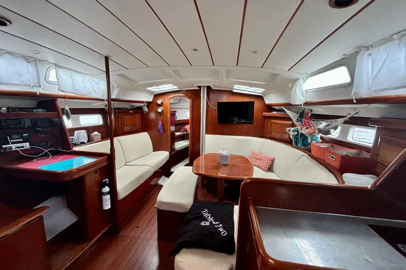 Slide: The Image of Interior of 2004 Beneteau Oceanis 423 sailboat with cozy seating and wooden finishes. - 13