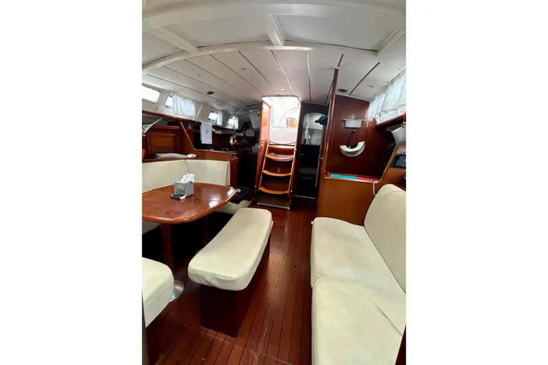 Slide: The Image of Interior of 2004 Beneteau Oceanis 423 sailboat, featuring cozy seating and wooden finishes. - 14