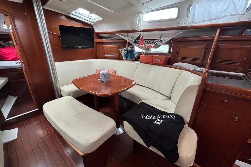 Slide: The Image of Interior of 2004 Beneteau Oceanis 423 yacht with cozy seating and wooden finishes. - 15