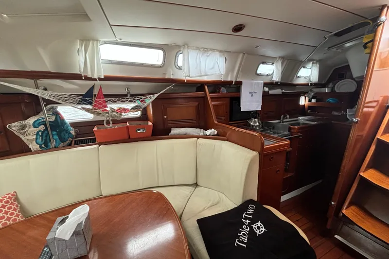 Slide: The Image of Interior of 2004 Beneteau Oceanis 423 sailboat with cozy seating and wooden cabinetry. - 16