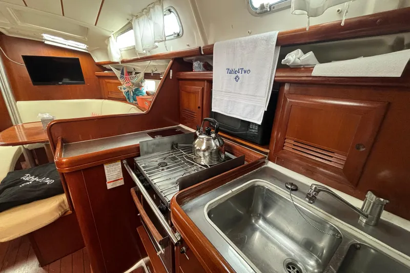 Slide: The Image of Interior of 2004 Beneteau Oceanis 423 yacht, featuring a cozy kitchen and dining area. - 18