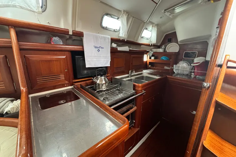 Slide: The Image of Galley of 2004 Beneteau Oceanis 423 sailboat with wood cabinetry and stainless steel appliances. - 19