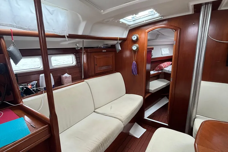 Slide: The Image of Interior of 2004 Beneteau Oceanis 423 sailboat with cozy seating and wooden finishes. - 21