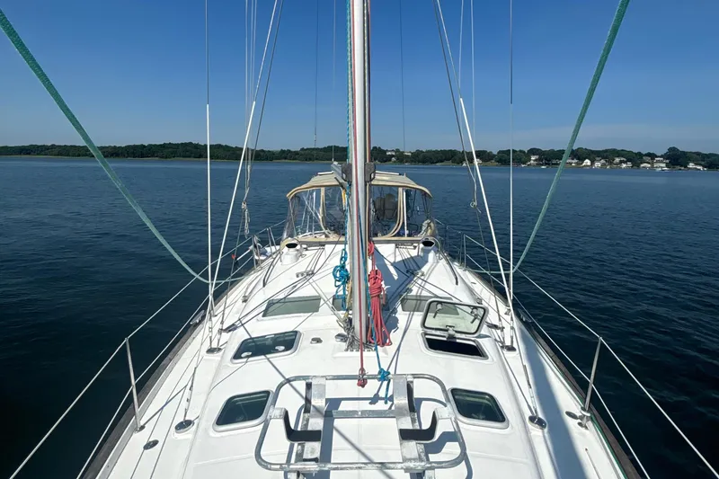Slide: The Image of 2004 Beneteau Oceanis 423 sailboat on calm water, clear sky, coastal background. - 5