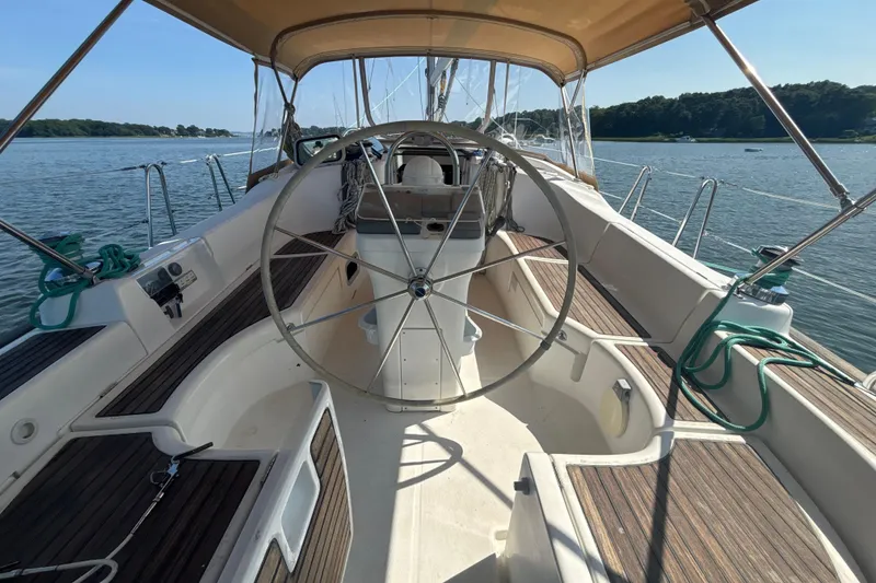 Slide: The Image of 2004 Beneteau Oceanis 423 sailboat cockpit with steering wheel, docked on calm water. - 8