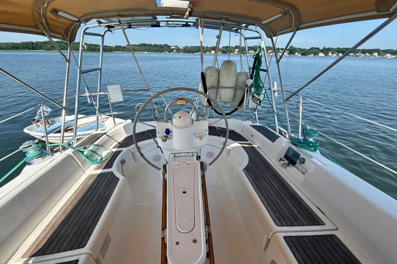 Slide: The Image of Cockpit view of 2004 Beneteau Oceanis 423 sailboat with steering wheel and open water backdrop. - 9