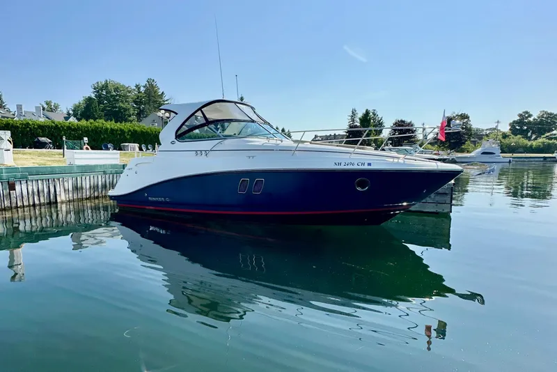 Slide: The Image of 2015 Rinker 340 Express Cruiser docked on calm water, sunny day. - 0