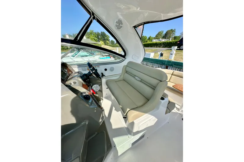 Slide: The Image of 2015 Rinker 340 Express Cruiser helm with beige seating and modern controls. - 11