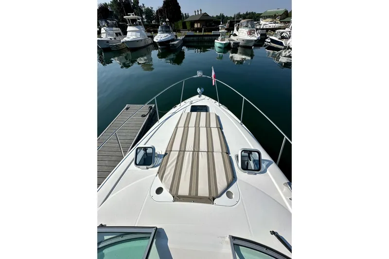 Slide: The Image of 2015 Rinker 340 Express Cruiser docked at marina, view from bow. - 13