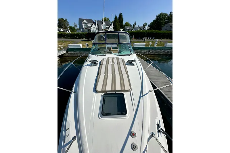 Slide: The Image of 2015 Rinker 340 Express Cruiser docked at marina, showcasing sleek design and spacious deck. - 14