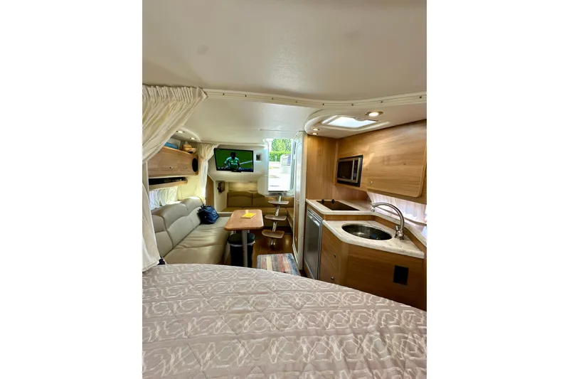 Slide: The Image of 2015 Rinker 340 Express Cruiser interior with kitchen, seating, and TV. - 23