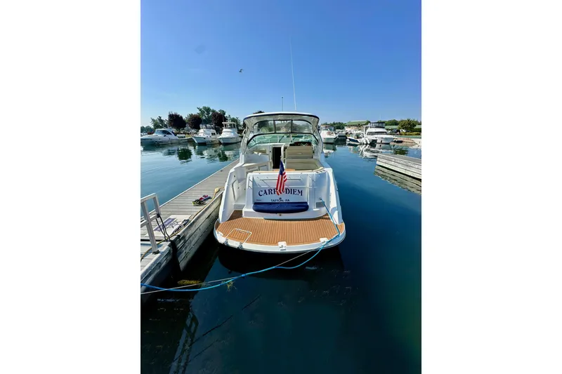 Slide: The Image of 2015 Rinker 340 Express Cruiser docked at marina under clear blue sky. - 3