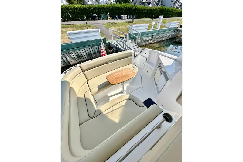 Slide: The Image of 2015 Rinker 340 Express Cruiser interior with beige seating and wooden table. - 9