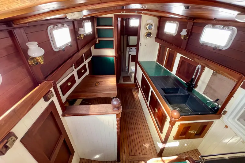 Slide: The Image of Interior of 2008 Pinky Custom boat with wooden cabinetry and compact kitchen area. - 17